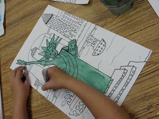 Coloring in statue of liberty on paper.